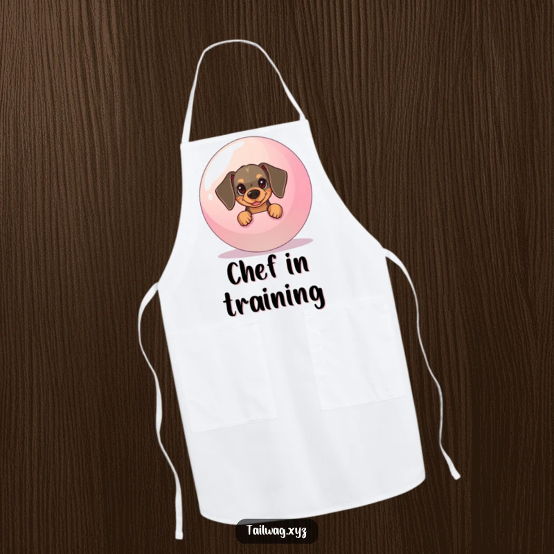 Funny Dachshund Apron: Mischievous dachshund peeking from behind a giant ball, a humorous and practical kitchen accessory.